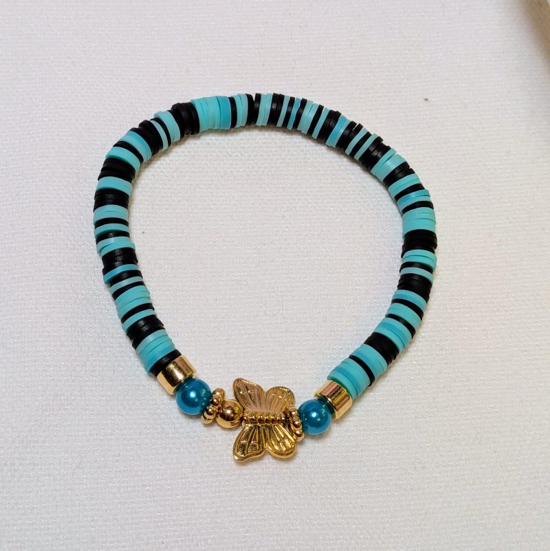  teal and black clay beads around a gold butterfly centrepiece