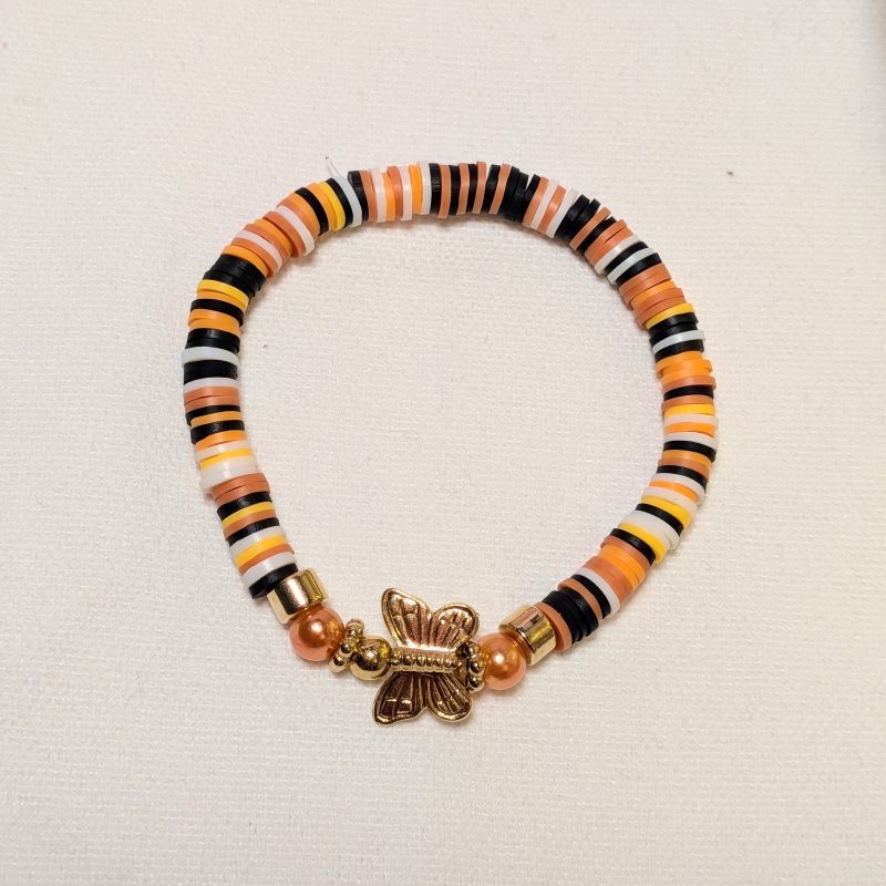 orange and black clay beads around a gold butterfly centrepiece