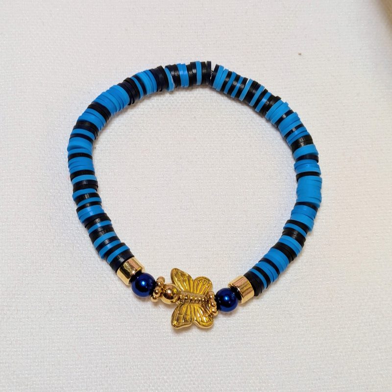 a blue and black clay beads around a gold butterfly centrepiece