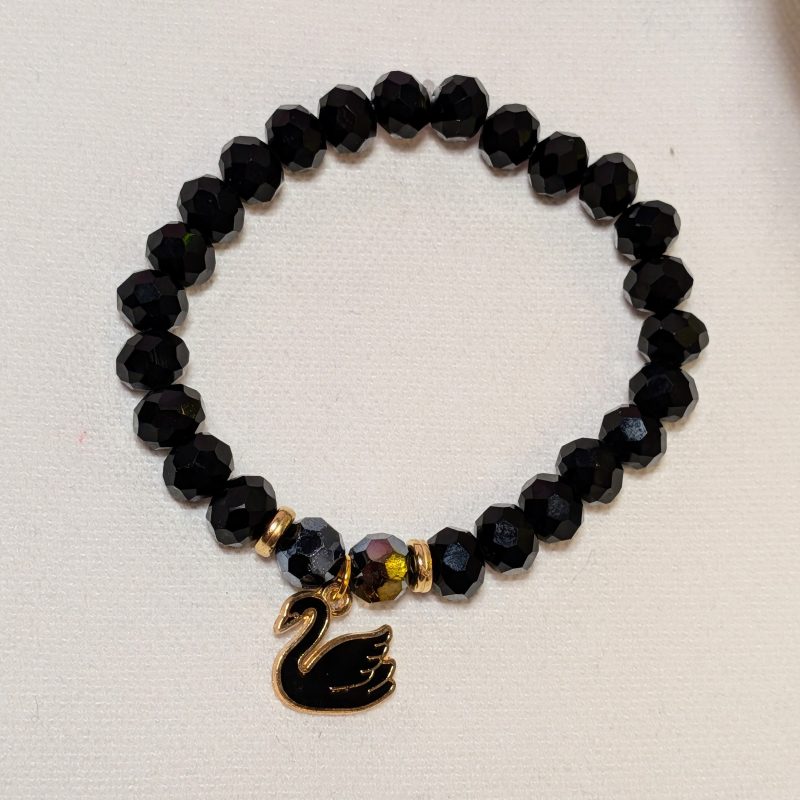 a black swan charm surrounded by black shaped beads