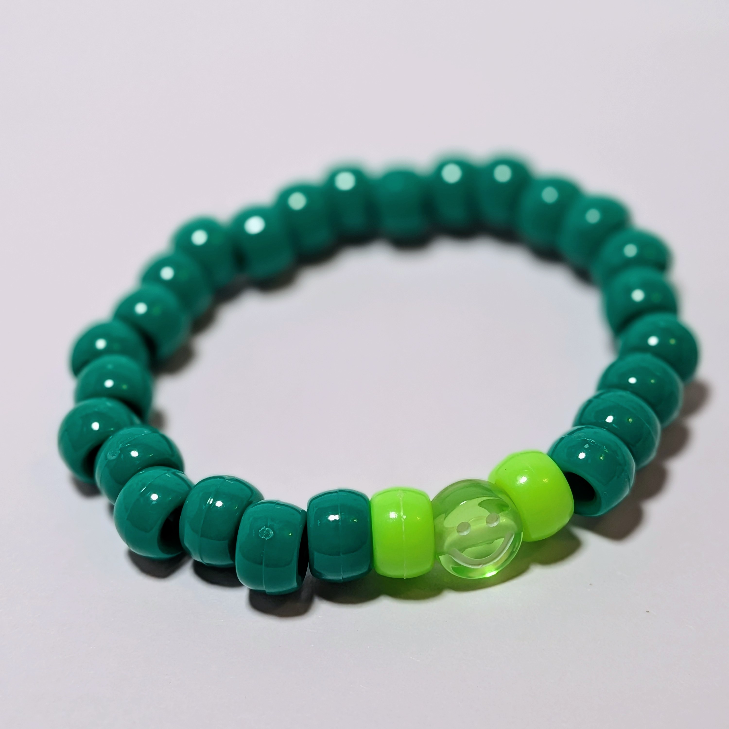 a smiley bead surrounded by matching thick beads