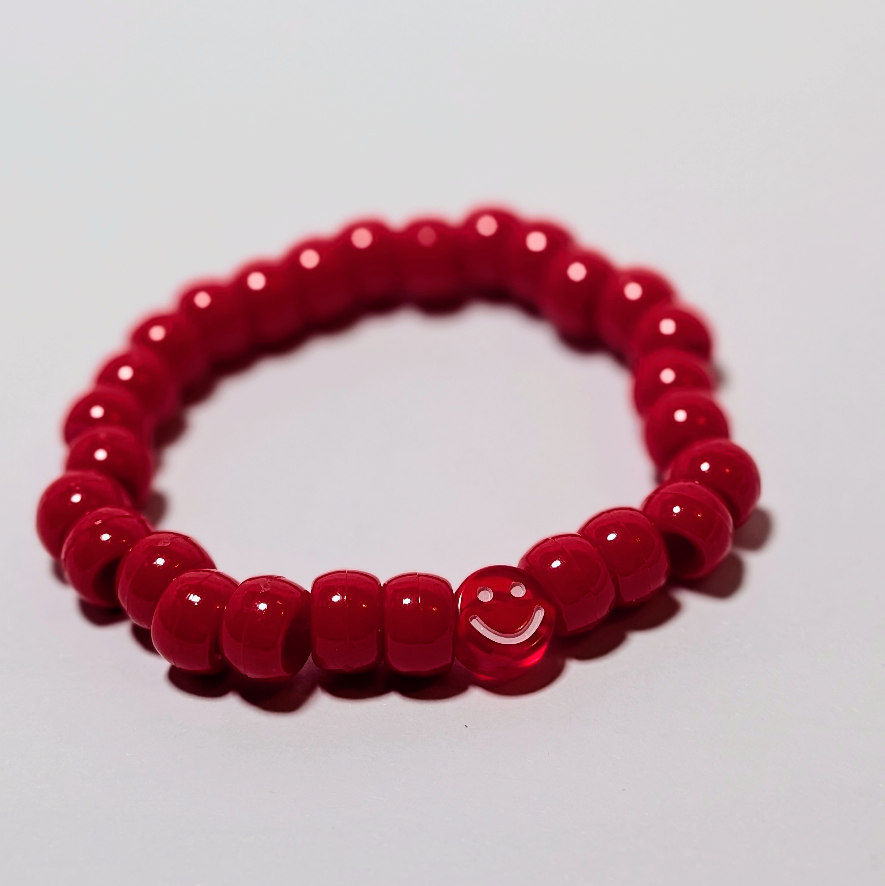 a smiley bead surrounded by matching thick beads