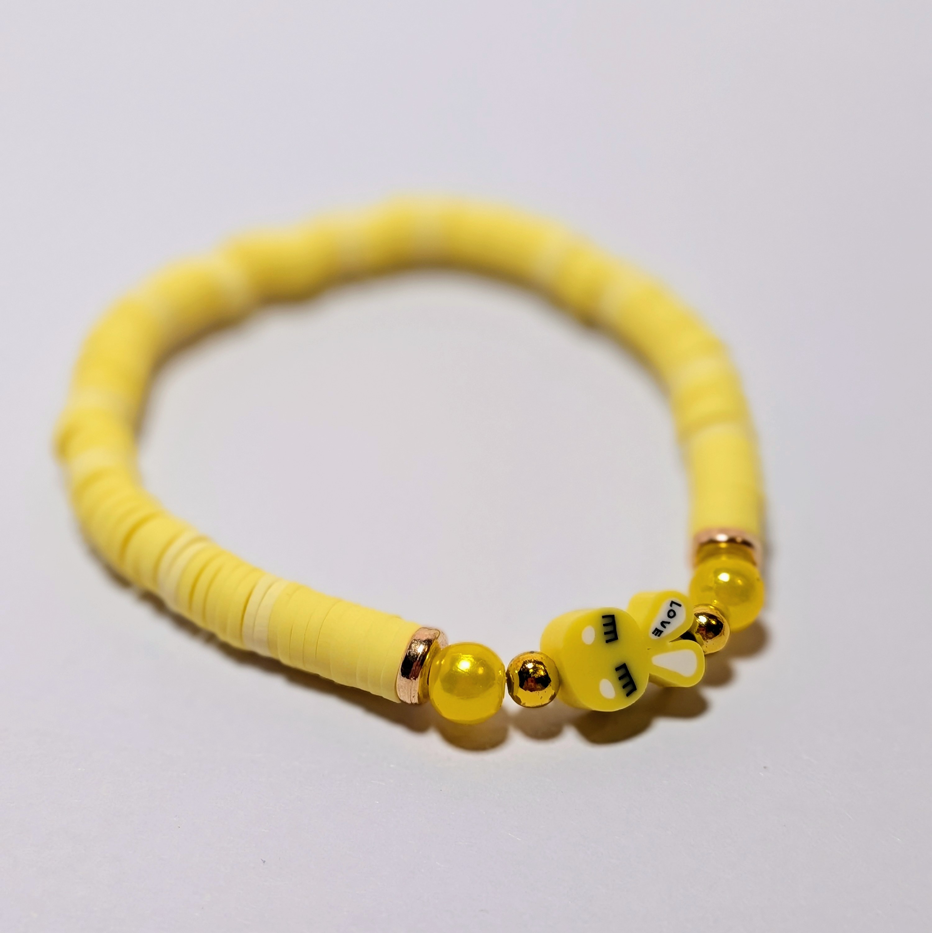 a yellow bunny bead surrounded by matching and contrasting clay beads