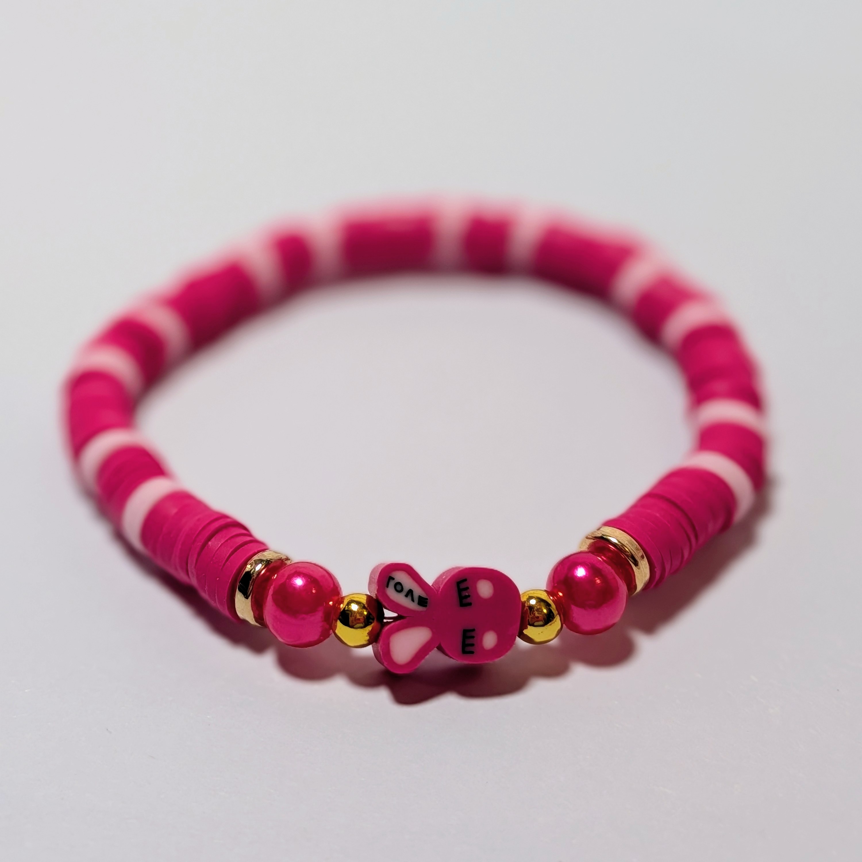 a red bunny bead surrounded by matching and contrasting clay beads