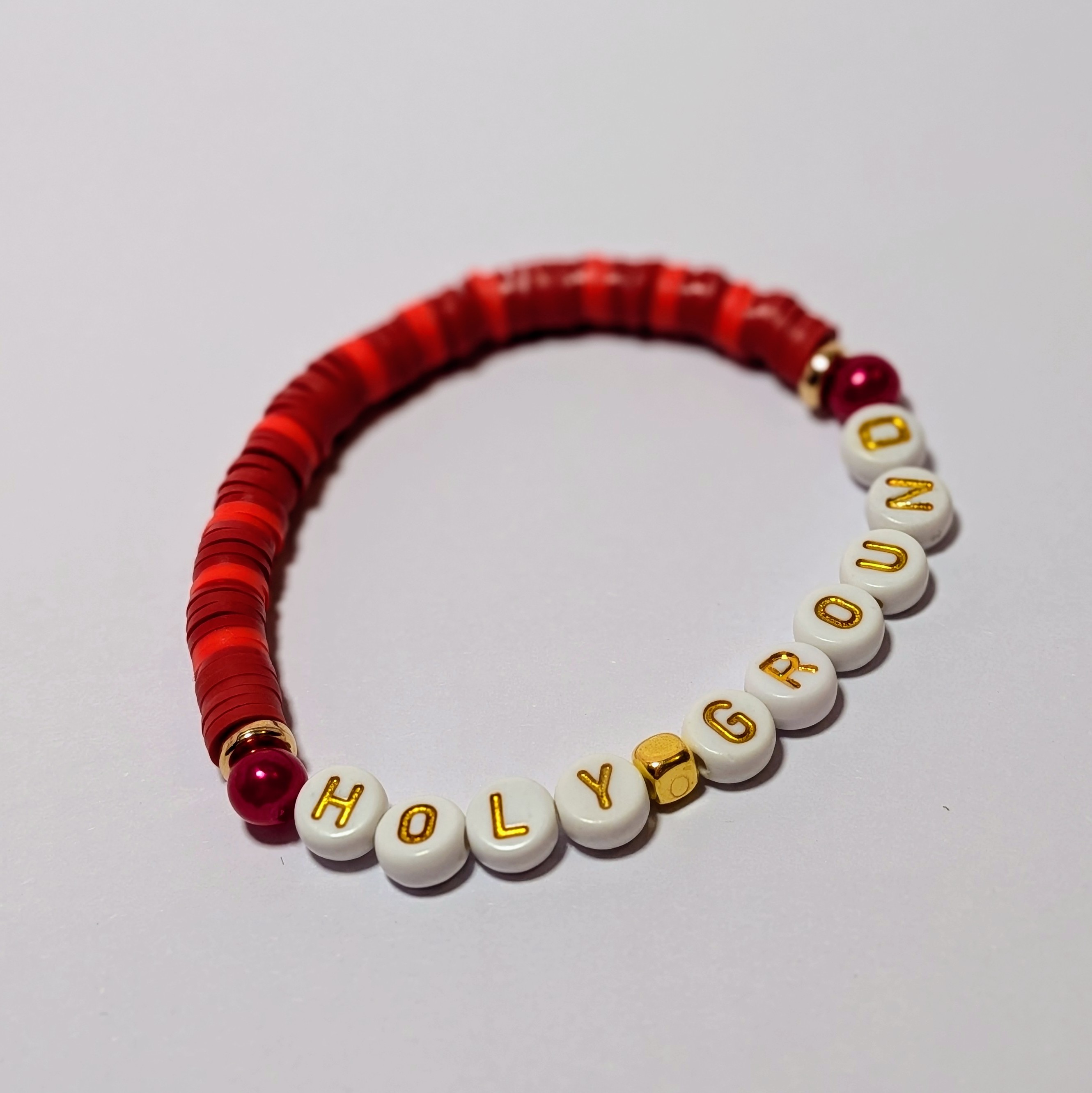 "HOLY GROUND" surrounded by matching and contrasting red clay beads.