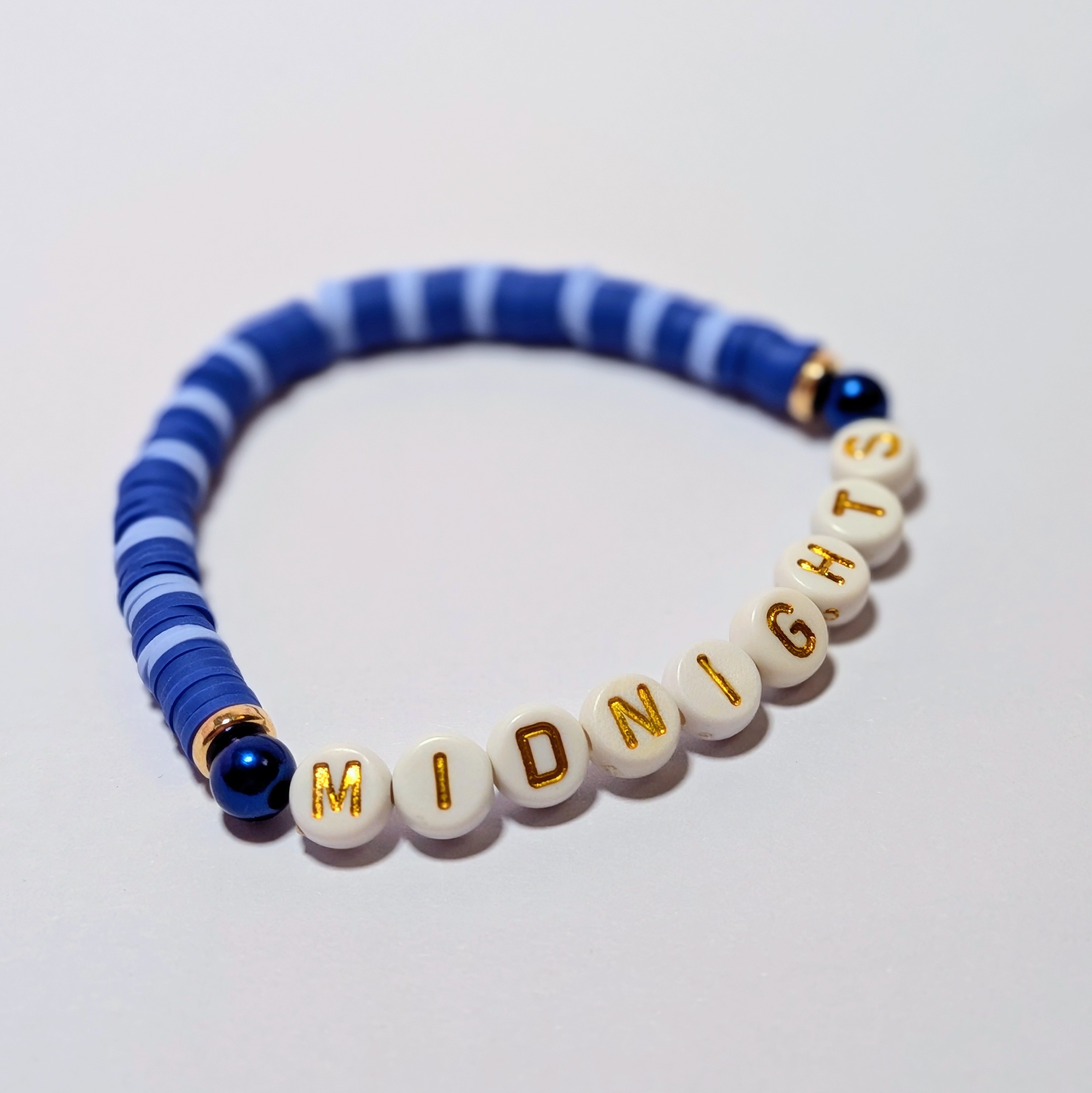  "MIDNIGHTS" surrounded by matching and contrasting blue clay beads.