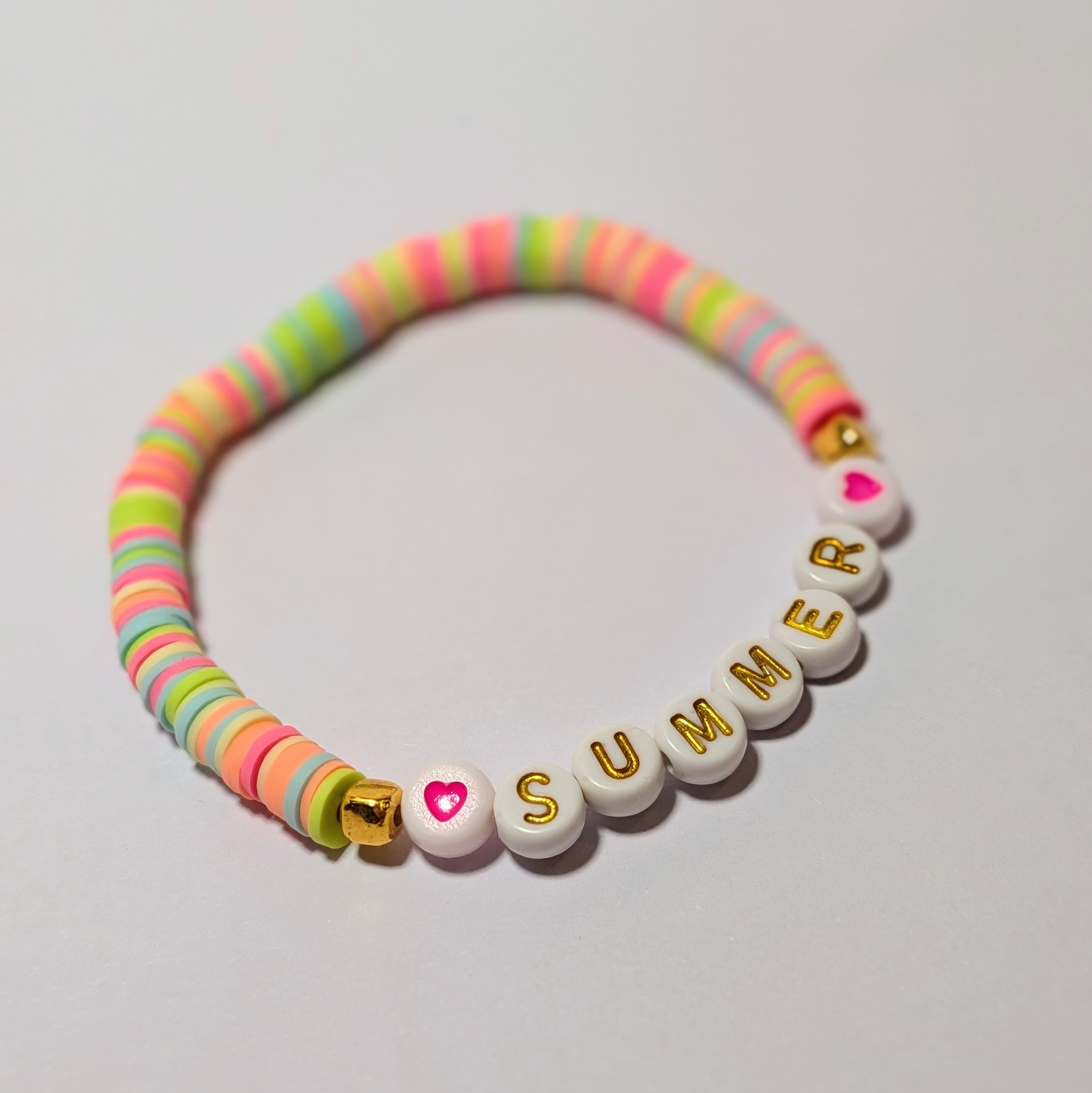  "SUMMER" surrounded by matching and contrasting clay beads.