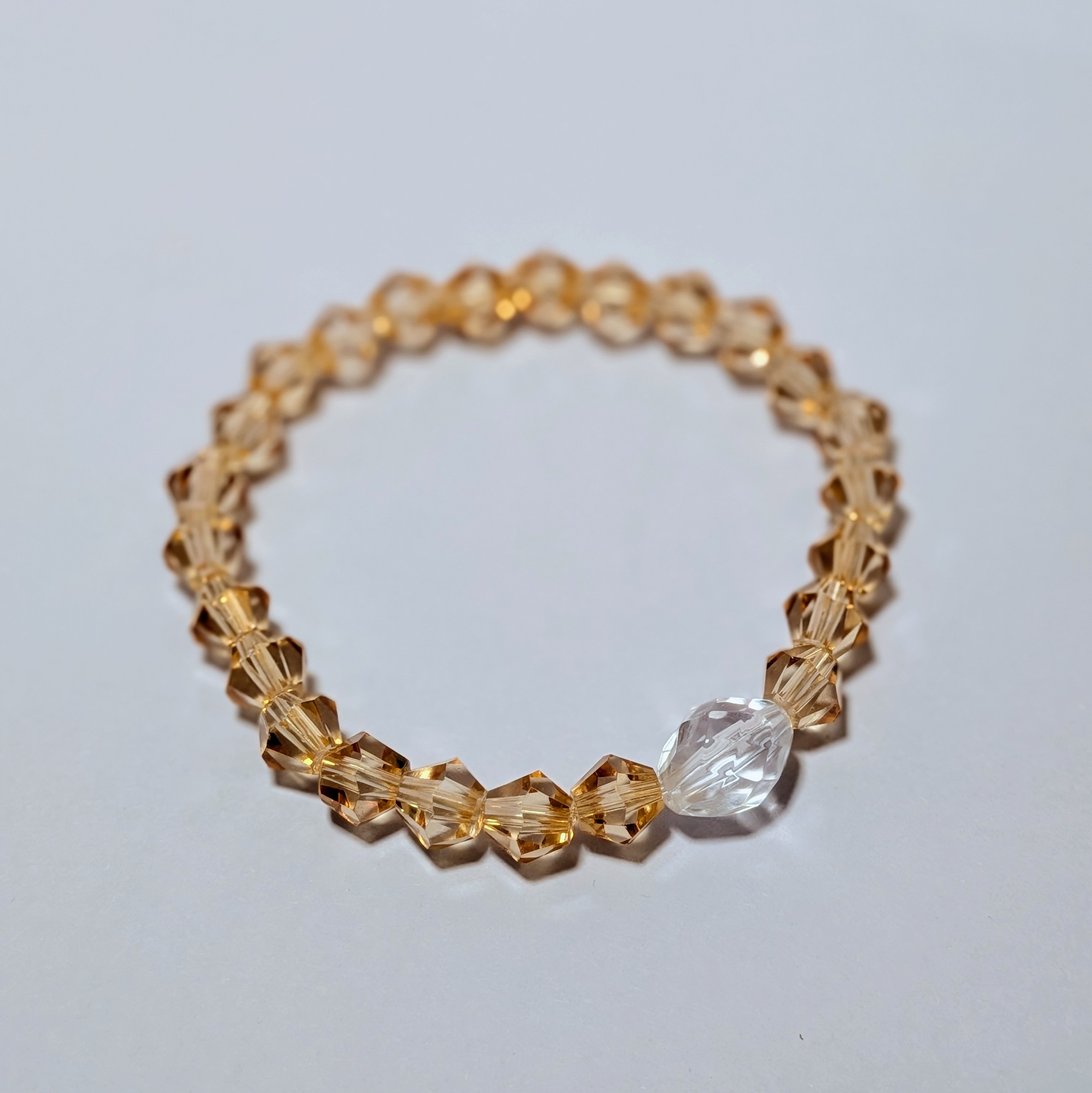  a larger clear glass like bead surrounded by smaller gold glass like beads