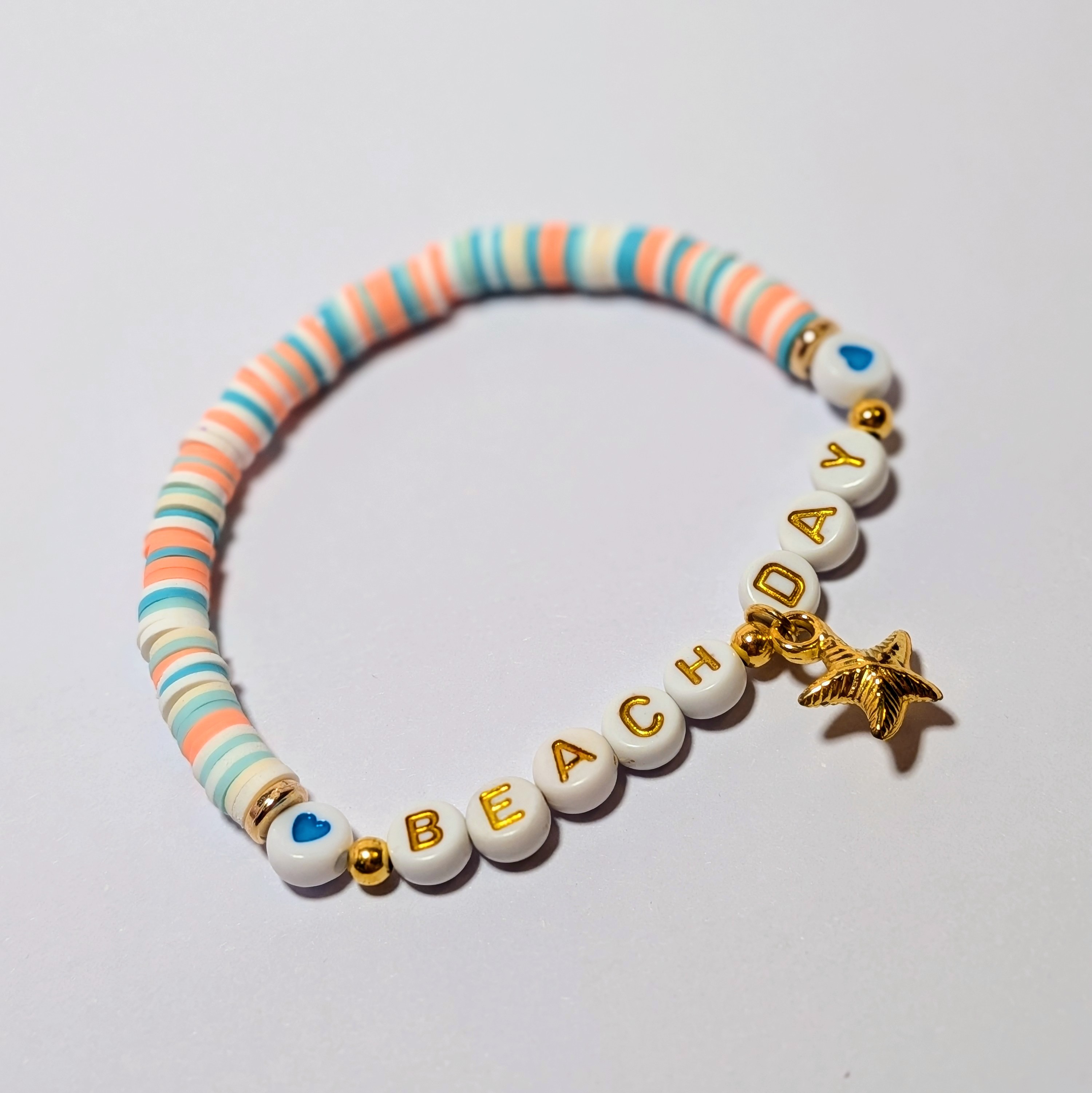 "BEACH DAY surrounded by matching and contrasting clay beads and starfish charm