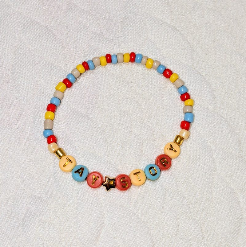 Dainty multicolour beads in tan, red, blue and yellow, with gold accents and letter beads.
