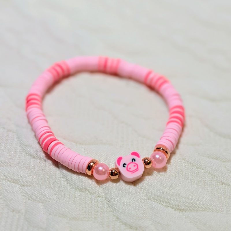 A pig bead with rose gold and pink pearl accent beads with pink clay beads