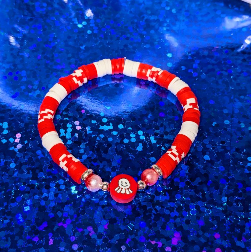 A crab centrepiece surrounded by red and white clay beads, silver spacers, and red white gradient accent beads — view 3