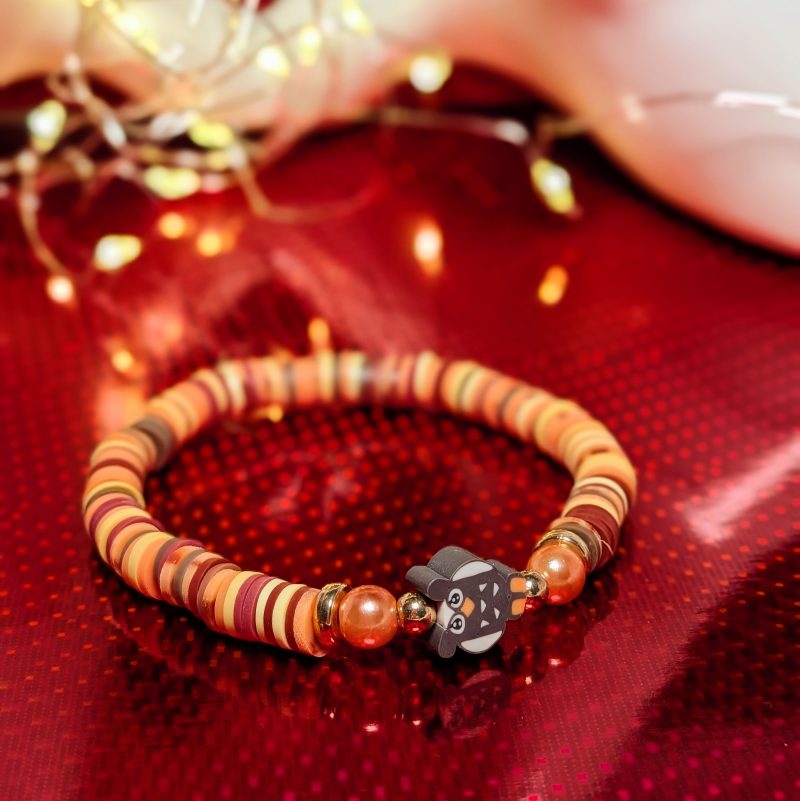A centrepiece brown and white owl withclay beads, orange accent beads and gold spacers
