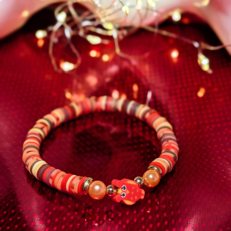 A centrepiece red and orange owl withclay beads, orange accent beads and gold spacers
