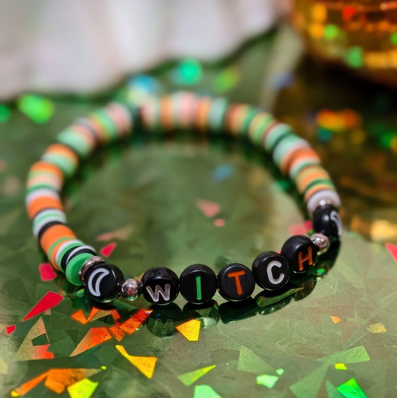 Halloween friendship bracelet that spells witch with green, white, black and orange beads