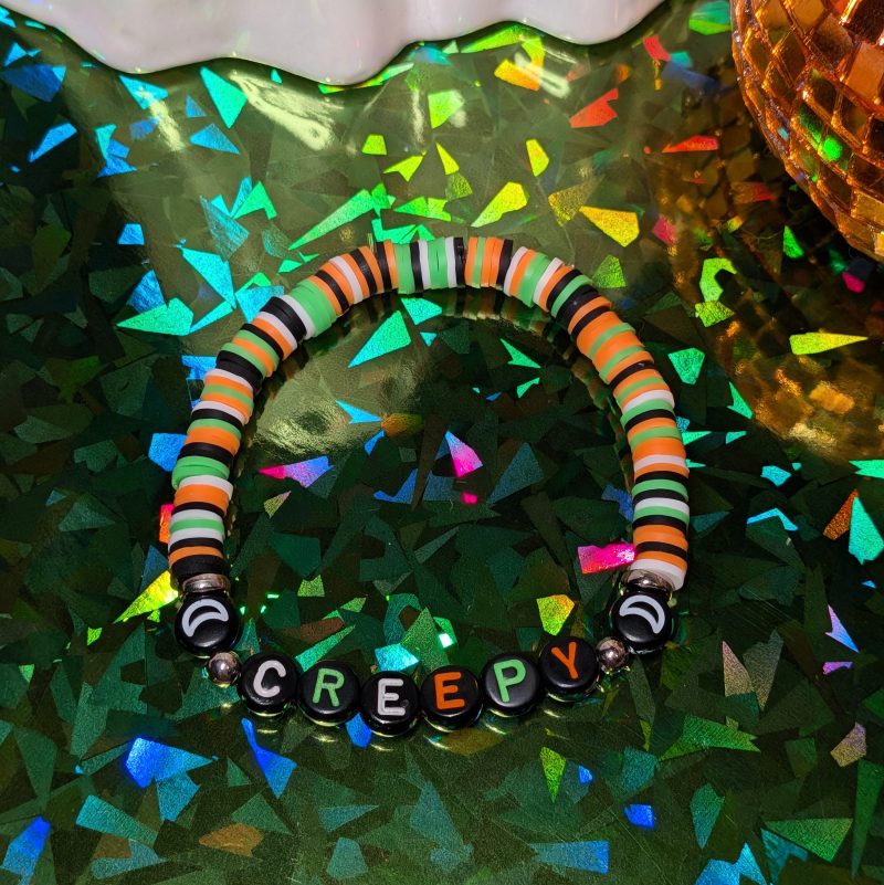 Halloween friendship bracelet that spells creepy with green, white, black and orange beads — view 3