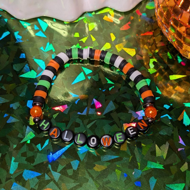 friendship bracelet that spells Halloween with green, white, black and orange beads — view 4