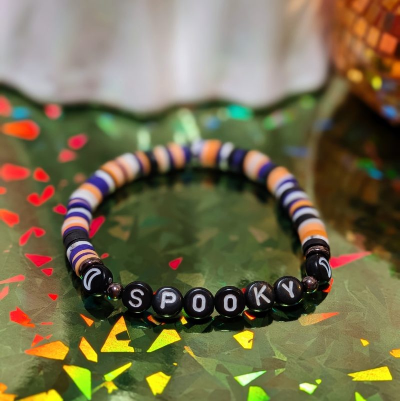 Halloween friendship bracelet that spells spooky with moon beads and white, black, orange and purple clay beads