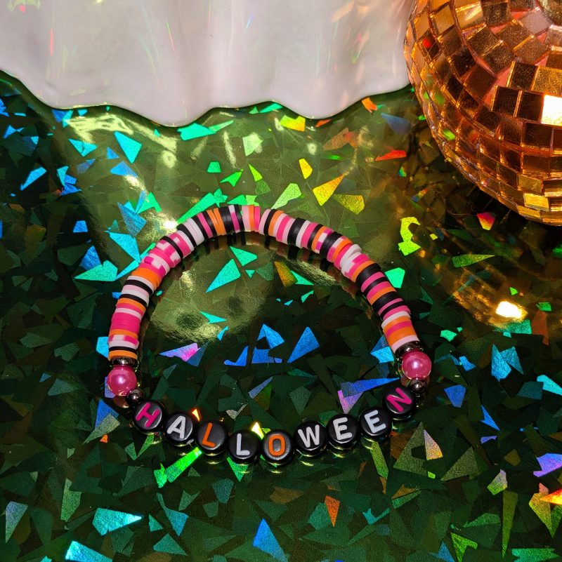 friendship bracelet that spells Halloween with pink, orange, white, and black beads — view 3