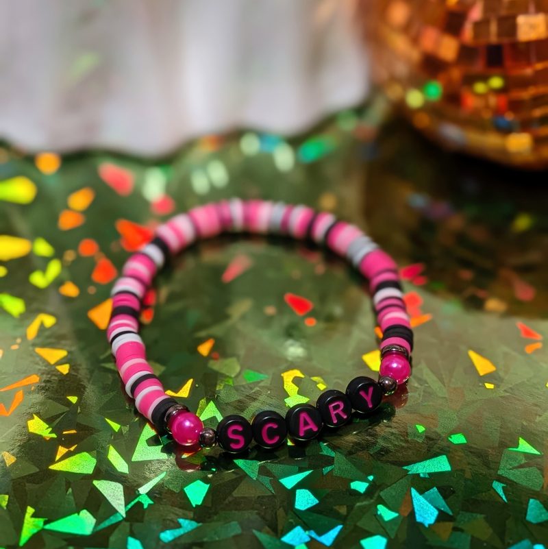 friendship bracelet that spells scary with pink, white, and black beads — view 2