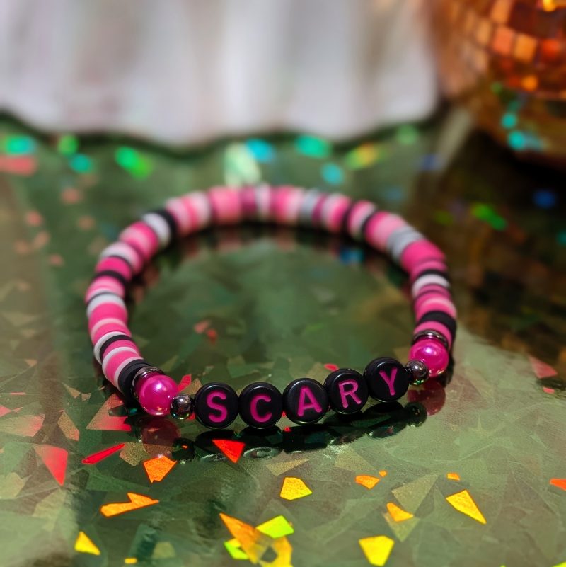 friendship bracelet that spells scary with pink, white, and black beads