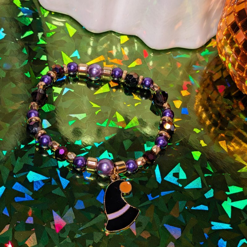 Halloween friendship bracelet with a witch hat charm. Gold accent spacers and beads in black and purple — view 3