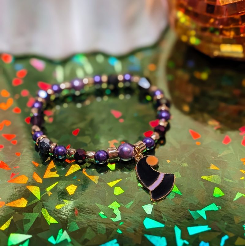 Halloween friendship bracelet with a witch hat charm. Gold accent spacers and beads in black and purple — view 2