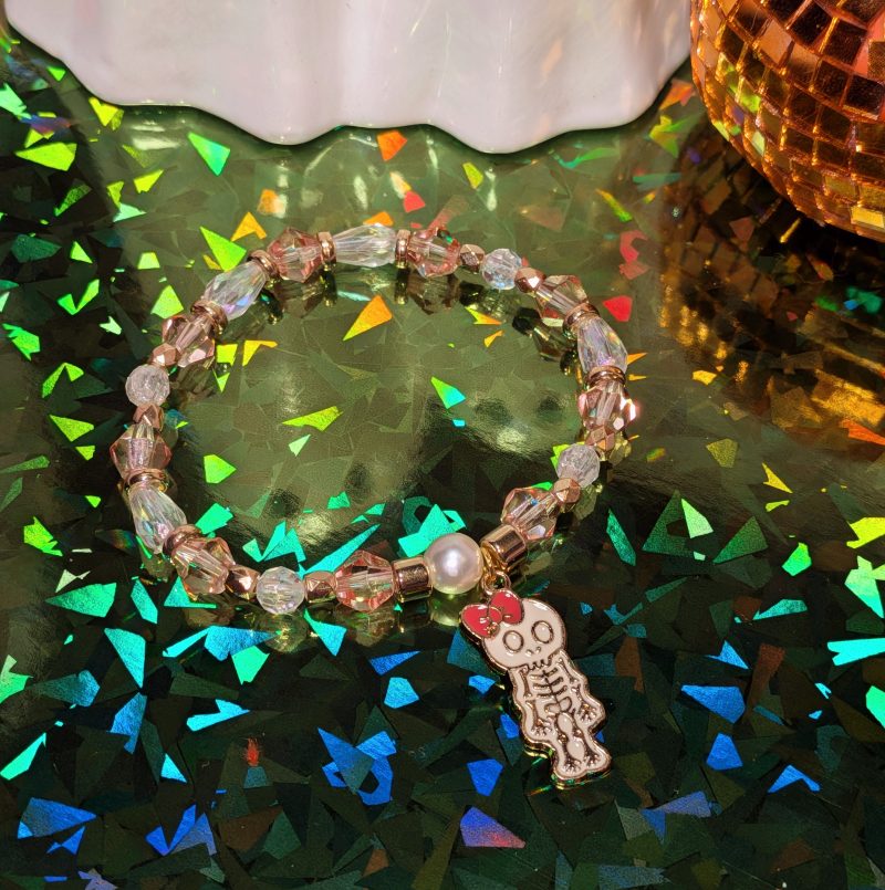 Halloween friendship bracelet with a witch hat charm. Gold accent spacers and beads in white and pink