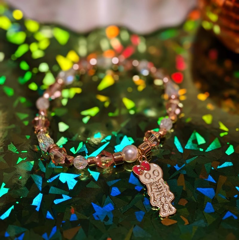 Halloween friendship bracelet with a witch hat charm. Gold accent spacers and beads in white and pink — view 3