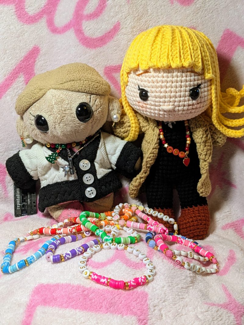 Miss Squish and Miss Stitch standing in front of bundles of colorful handmade Bestie friendship bracelets